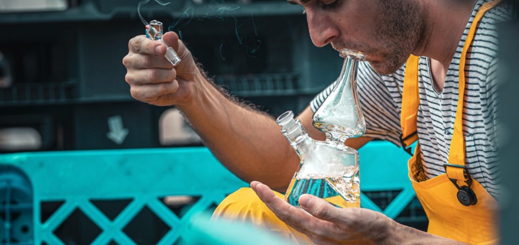 Person Using a Bong to Consume Weed